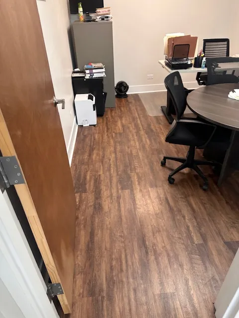 Clean commercial meeting room with a round table, office chairs, and polished floors